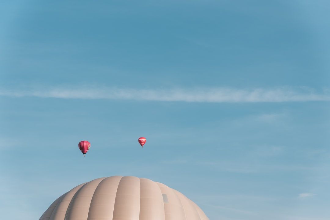 Färgglada luftballonger som svävar i luften mot en blå himmel.
